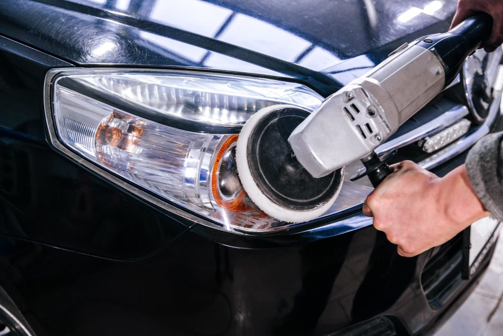 polishing car headlights at shallow depth of field Car headlight cleaning polishing machine at car service at shallow depth of field