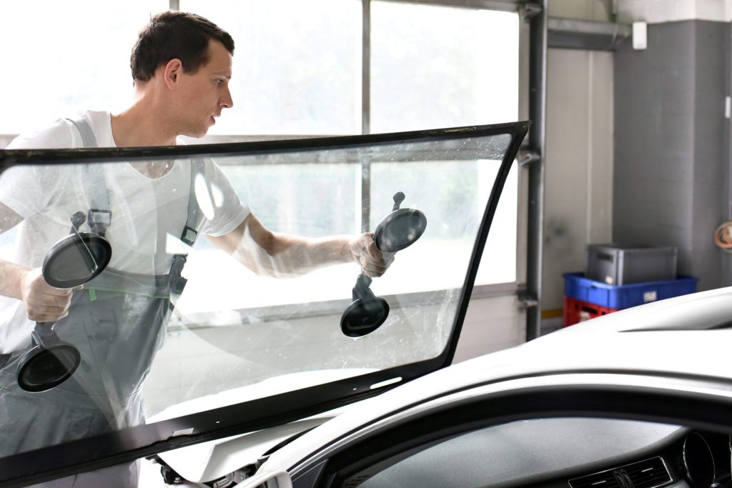 Austausch der Frontscheibe in einer Werkstatt durch professionel Carrossier qui remplace un par-brise avant-Carrosserie Fayet
